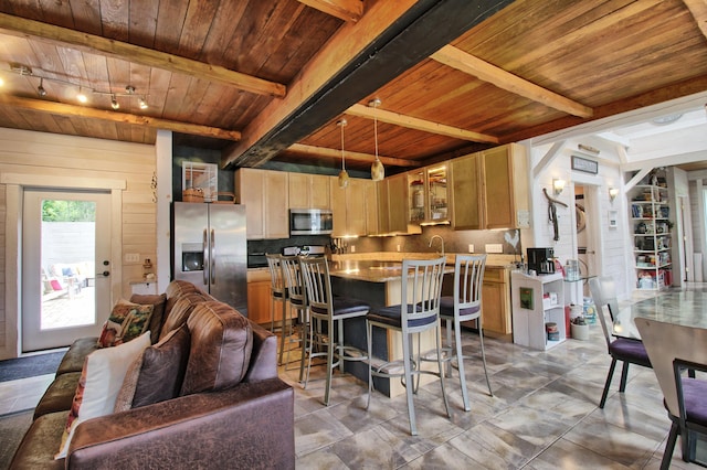 kitchen with beamed ceiling, hanging light fixtures, wood ceiling, track lighting, and stainless steel appliances