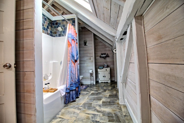 bathroom with toilet, wood walls, and shower / bath combo