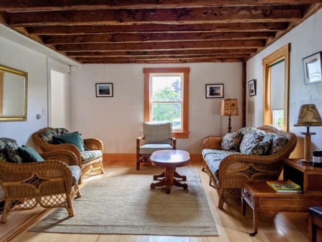 living room with beam ceiling and light hardwood / wood-style floors