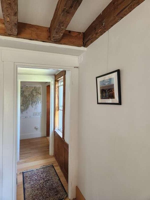 corridor featuring light hardwood / wood-style floors and beam ceiling