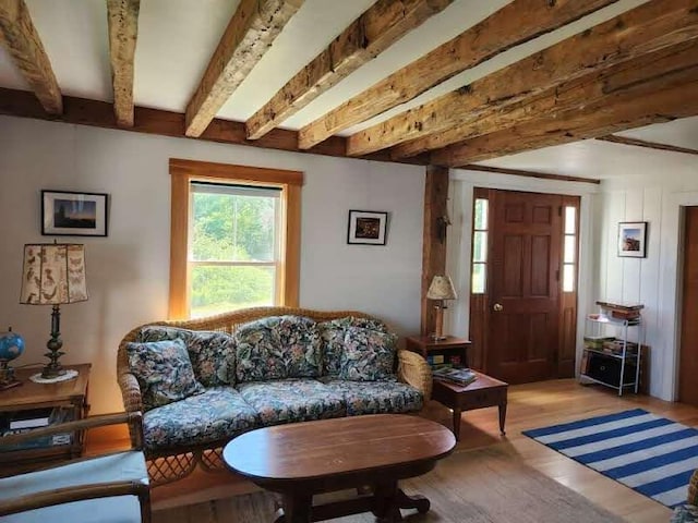 living area featuring beam ceiling and light hardwood / wood-style floors