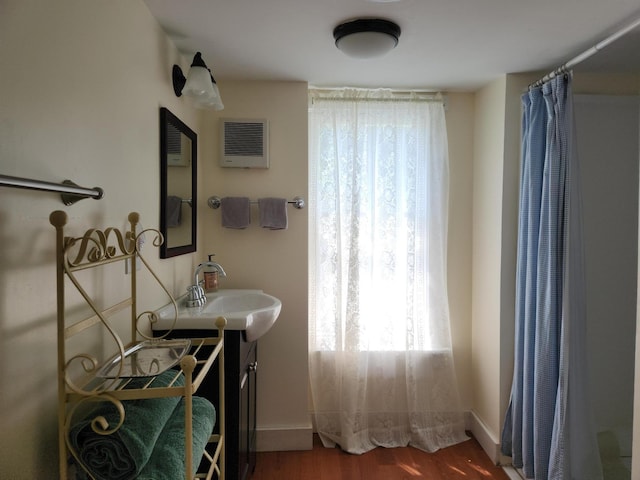 bathroom with wood-type flooring, sink, and a shower with shower curtain