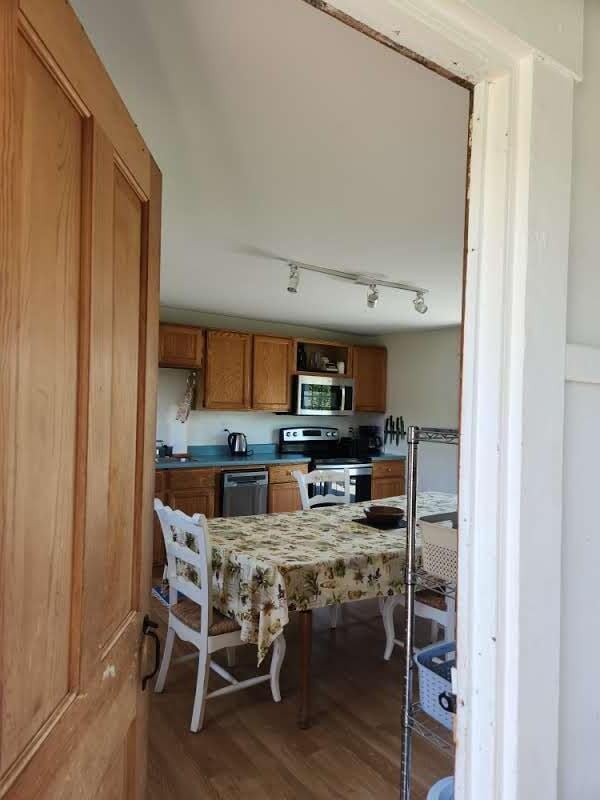 kitchen with hardwood / wood-style flooring and appliances with stainless steel finishes