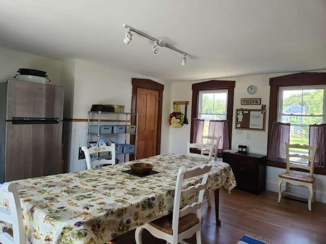 dining space featuring rail lighting and dark hardwood / wood-style floors