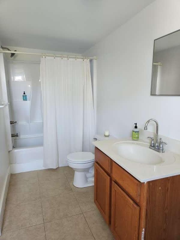 full bathroom featuring toilet, shower / tub combo, tile patterned floors, and vanity