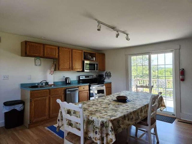 kitchen featuring appliances with stainless steel finishes, sink, and hardwood / wood-style flooring