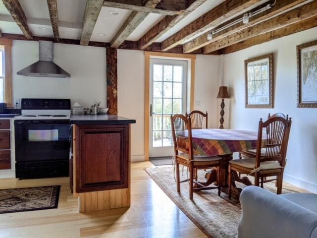 dining area with beam ceiling and light wood-type flooring