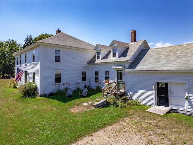 rear view of house featuring a yard