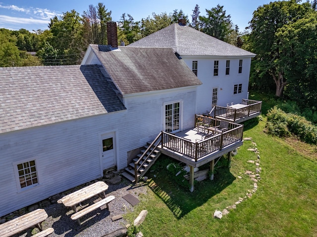 rear view of house featuring a yard and a wooden deck