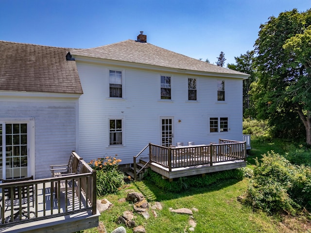 rear view of house featuring a wooden deck, a lawn, and central air condition unit