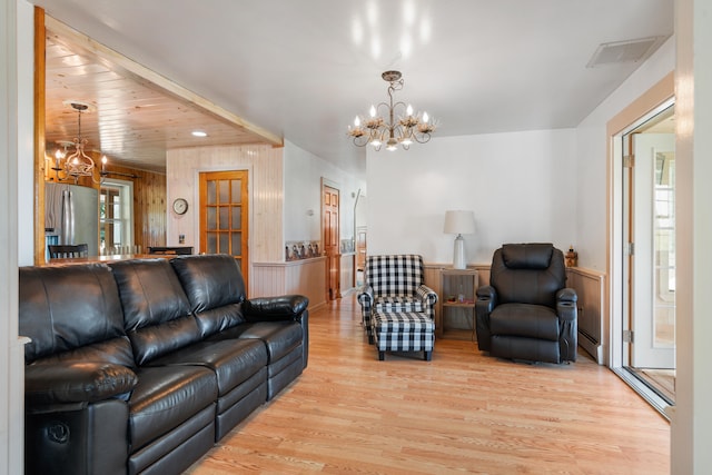 living room with a baseboard radiator, an inviting chandelier, and light hardwood / wood-style flooring