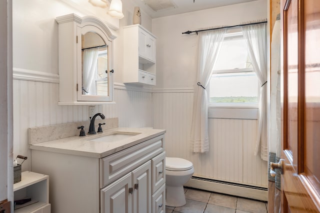 bathroom with tile flooring, baseboard heating, vanity, and toilet