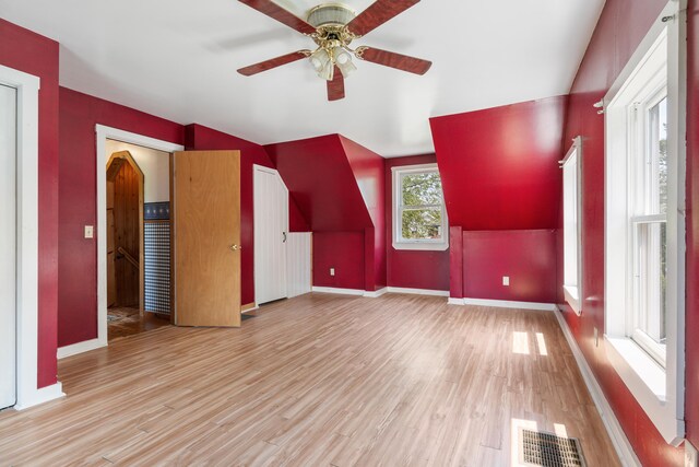 unfurnished living room featuring ceiling fan, light hardwood / wood-style floors, and lofted ceiling