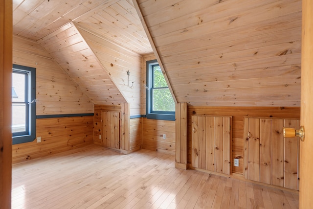 bonus room featuring wooden ceiling, wooden walls, light wood-type flooring, and lofted ceiling