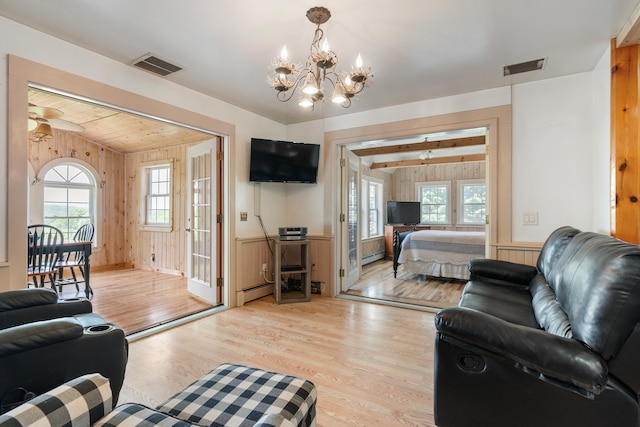 living room featuring vaulted ceiling with beams, a baseboard radiator, light hardwood / wood-style flooring, and ceiling fan with notable chandelier