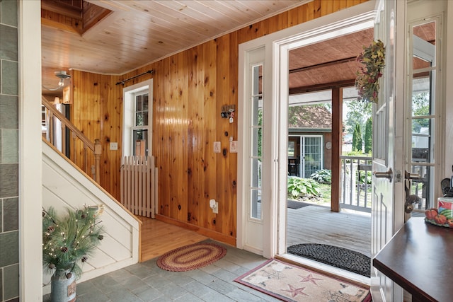 foyer entrance with wood walls, wood ceiling, and wood-type flooring