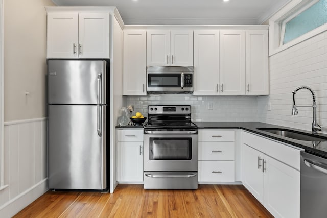 kitchen with white cabinets, sink, appliances with stainless steel finishes, and tasteful backsplash