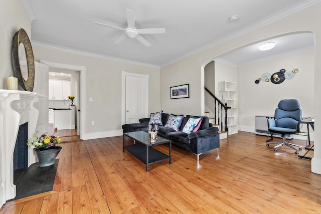 living room featuring ceiling fan, light hardwood / wood-style floors, and ornamental molding