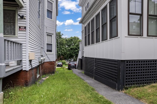 view of side of home with a lawn