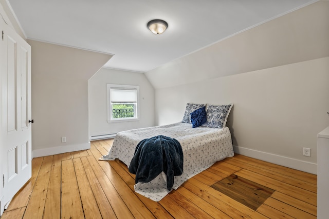 bedroom featuring a baseboard heating unit, light wood-type flooring, and lofted ceiling