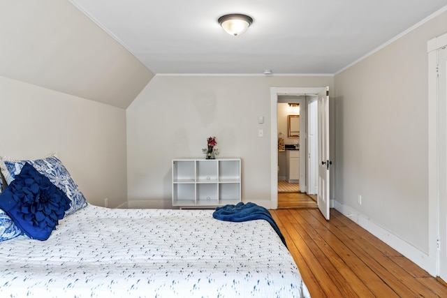 bedroom featuring hardwood / wood-style flooring, lofted ceiling, and ornamental molding