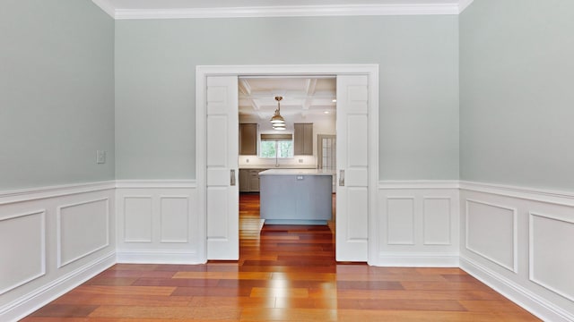 unfurnished room featuring crown molding, coffered ceiling, and hardwood / wood-style flooring