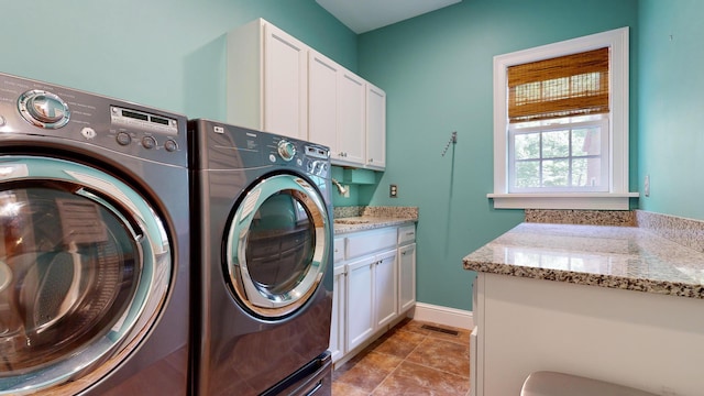 washroom with washing machine and dryer and cabinets