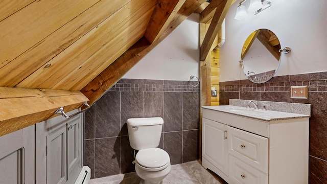 bathroom with toilet, tile walls, vaulted ceiling, and vanity