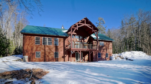 snow covered property with a wooden deck