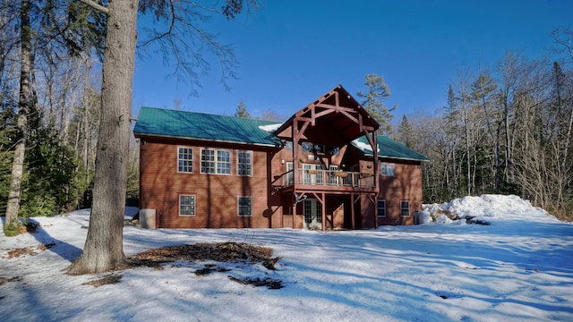 snow covered property with a deck