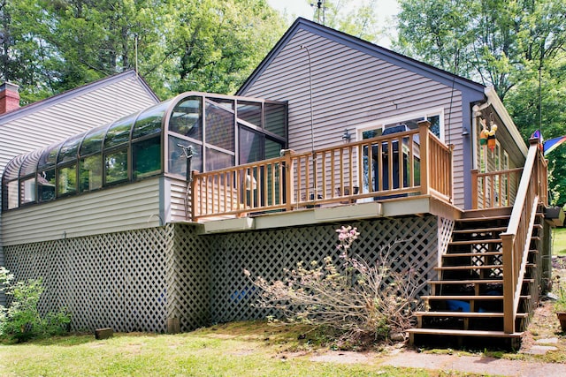 rear view of house featuring a deck and a sunroom