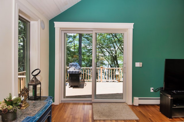 entryway featuring lofted ceiling, baseboard heating, a wealth of natural light, and light hardwood / wood-style flooring