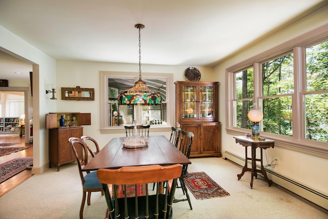 carpeted dining area featuring a baseboard heating unit