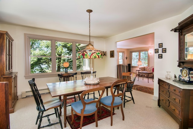 carpeted dining room with a baseboard heating unit