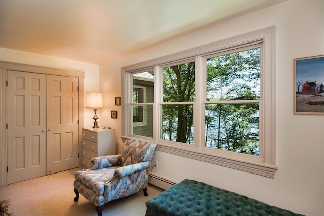 sitting room with a baseboard radiator and light carpet