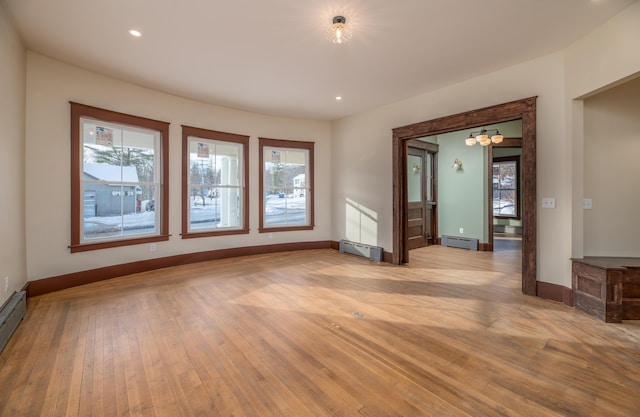 empty room featuring light wood-type flooring and baseboard heating