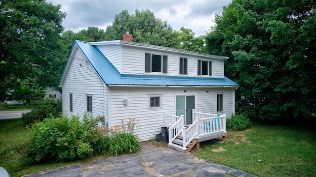 back of property with a deck and a yard