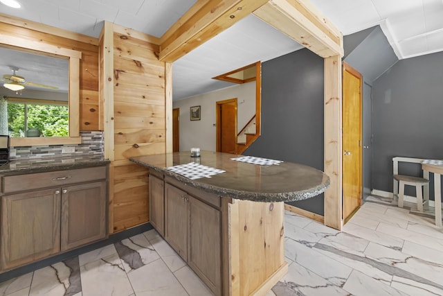 kitchen with a kitchen breakfast bar, kitchen peninsula, ceiling fan, and tasteful backsplash