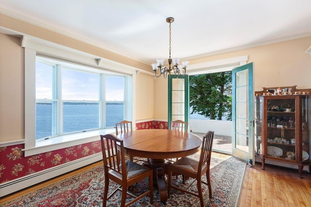 LTS23A Birch Is, South Bristol, ME 04568 - dining space with a baseboard heating unit, a chandelier, a water view, light wood finished floors, and crown molding