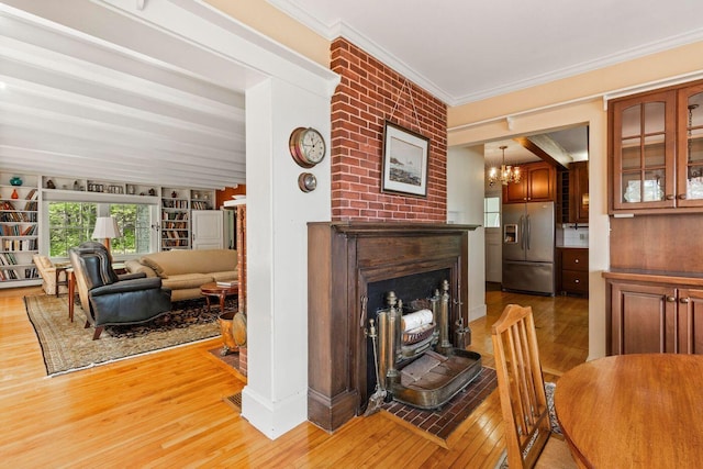 LTS23A Birch Is, South Bristol, ME 04568 - dining area with light wood finished floors, a chandelier, a fireplace with raised hearth, and ornamental molding