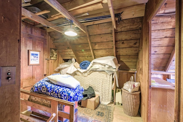 bedroom featuring lofted ceiling and wood walls