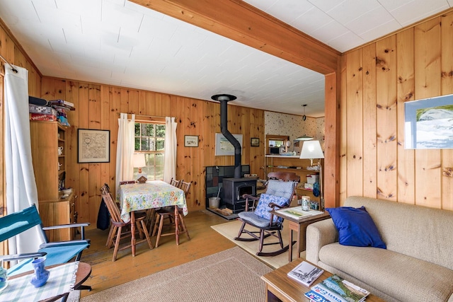 living room featuring a wood stove, wood walls, and light hardwood / wood-style flooring