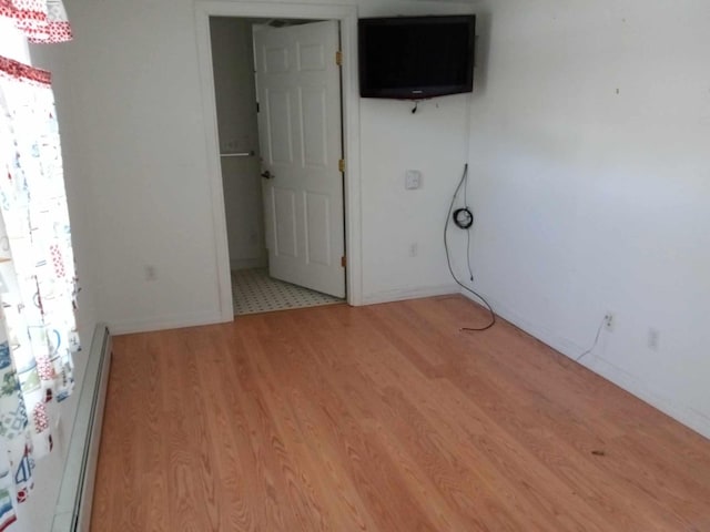 spare room featuring light hardwood / wood-style floors and a baseboard radiator