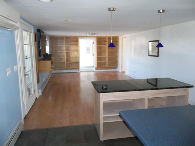 kitchen featuring a wall mounted AC, dark hardwood / wood-style floors, a baseboard radiator, hanging light fixtures, and built in shelves