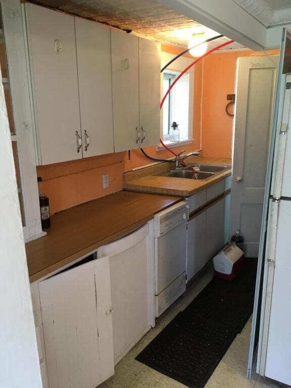 kitchen with sink, white appliances, and white cabinetry