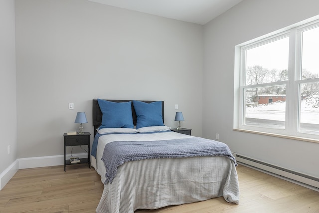 bedroom featuring hardwood / wood-style flooring and a baseboard radiator