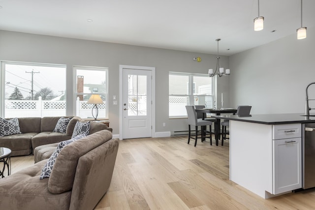 living room with an inviting chandelier and light hardwood / wood-style flooring