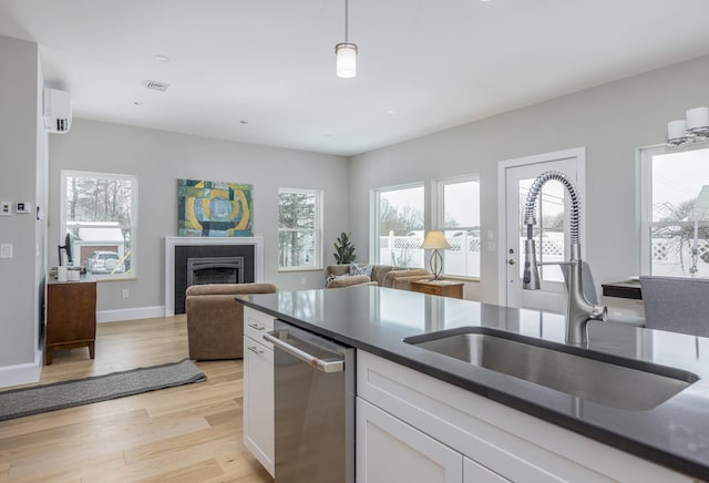 kitchen with a wealth of natural light, dishwasher, sink, and white cabinets