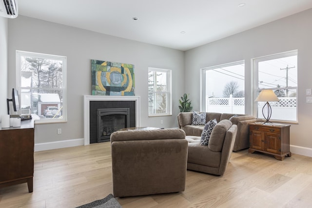 living room featuring a wall mounted AC and light wood-type flooring