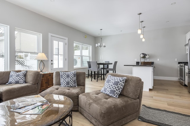 living room with an inviting chandelier and light hardwood / wood-style floors